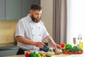 Young prepares a poke bowl in a modern kitchen. The man prepares food at home. Cooking healthy and tasty food