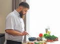 Young prepares a poke bowl in a modern kitchen. The man prepares food at home. Cooking healthy and tasty food