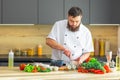 Young prepares a poke bowl in a modern kitchen. The man prepares food at home. Cooking healthy and tasty food