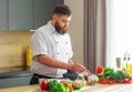 Young prepares a poke bowl in a modern kitchen. The man prepares food at home. Cooking healthy and tasty food