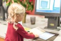 Young preschool aged girl using the self check-out at the library