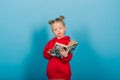 Young preschool child learns while reading a book, on blue