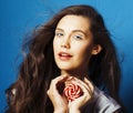 Young pretty adorable brunette woman with candy close up posing on blue background, like doll makeup, fashion beauty Royalty Free Stock Photo