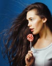 Young pretty adorable brunette woman with candy close up posing on blue background, like doll makeup, fashion beauty Royalty Free Stock Photo