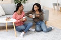 Young pretty girlfriends drinking coffee at home Royalty Free Stock Photo