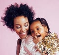 Young pretty african-american mother with little cute daughter hugging, happy smiling on pink background, lifestyle Royalty Free Stock Photo