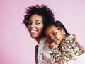 Young pretty african-american mother with little cute daughter hugging, happy smiling on pink background, lifestyle Royalty Free Stock Photo