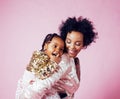 Young pretty african-american mother with little cute daughter hugging, happy smiling on pink background, lifestyle Royalty Free Stock Photo