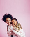 Young pretty african-american mother with little cute daughter hugging, happy smiling on pink background, lifestyle Royalty Free Stock Photo