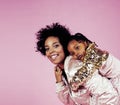 Young pretty african-american mother with little cute daughter hugging, happy smiling on pink background, lifestyle Royalty Free Stock Photo