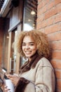 Young pretty african american women drinking coffee outside in cafe, modern business woman lifestyle concept Royalty Free Stock Photo