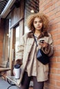 Young pretty african american women drinking coffee outside in cafe, modern business woman lifestyle concept Royalty Free Stock Photo