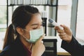 The young pretty Asian employee wearing face mask for COVID-19 virus pandemic prevention
