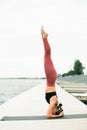 Young Pretty asian girl doing yoga outdoors on the pier by the lake Royalty Free Stock Photo