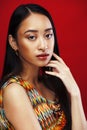 Young pretty asian girl with makeup posing on red background, lifestyle diverse rases people concept Royalty Free Stock Photo