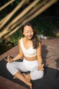 Young fit asian woman doing yoga by the lake in the morning park Royalty Free Stock Photo