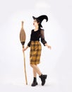 Young pretty asian woman in halloween costume wearing witch hat holding broom to celebrate Halloween party posing on white Royalty Free Stock Photo