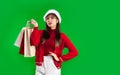 Young pretty asian woman in red and white christmas theme costume wearing santa hat carrying paper shopping bags Royalty Free Stock Photo