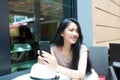 Young pretty asian woman relaxing and holding smart phone Royalty Free Stock Photo