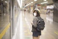 A young pretty Asian woman is wearing protective mask standing in metro station, New normal travel, covid-19 protection , safe Royalty Free Stock Photo