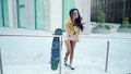 Pretty athletic girl rides a longboard in modern city