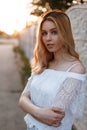 Young pretty attractive woman with blue eyes with natural make-up in an elegant lacy t-shirt posing outdoors near a vintage fence Royalty Free Stock Photo