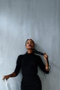 Young pretty black american woman touching her thick plait on dark studio background Royalty Free Stock Photo