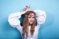 young pretty blond girl posing on blue background, fashion style hippie boho flowers on head Royalty Free Stock Photo