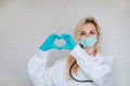 Doctor making the heart symbol by her hands on a white background with copy space