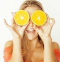 Young pretty blond woman with half oranges close Royalty Free Stock Photo