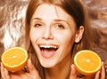 Young pretty blond woman with half oranges close up on white bright teenage smiling Royalty Free Stock Photo