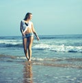 Young pretty blond woman at seacoast walking relaxing, fashion lady at sunset, lifestyle people vacations concept