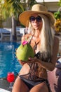 Young pretty blonde woman in swimming pool with coconut cocktail Royalty Free Stock Photo