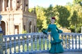 Young, pretty, blonde woman in typical green colored flamenco suit, posing leaning on a tiled railing over a bridge. Flamenco Royalty Free Stock Photo