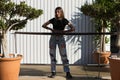 Young, pretty blonde woman wearing ripped jeans and black top. White wooden hut in background. The woman is wearing make-up. Royalty Free Stock Photo