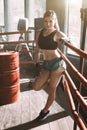 Young pretty boxer woman standing on ring. Full body portrait of boxer woman wearing black sports bra, grey trousers Royalty Free Stock Photo