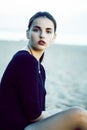 Young pretty brunette girl with long hair waiting alone on sand at seacoast, lifestyle people concept Royalty Free Stock Photo