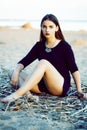 Young pretty brunette girl with long hair waiting alone on sand at seacoast, lifestyle people concept Royalty Free Stock Photo