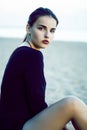 Young pretty brunette girl with long hair waiting alone on sand at seacoast, lifestyle people concept Royalty Free Stock Photo