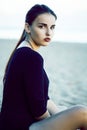 Young pretty brunette girl with long hair waiting alone on sand at seacoast, lifestyle people concept Royalty Free Stock Photo