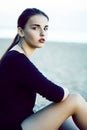 Young pretty brunette girl with long hair waiting alone on sand at seacoast, lifestyle people concept Royalty Free Stock Photo