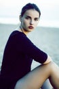 Young pretty brunette girl with long hair waiting alone on sand at seacoast, lifestyle people concept Royalty Free Stock Photo