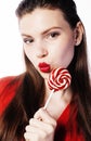 Young pretty brunette girl with red candy posing on white background isolated Royalty Free Stock Photo