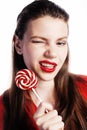 Young pretty brunette girl with red candy posing on white background isolated Royalty Free Stock Photo