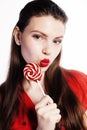 Young pretty brunette girl with red candy posing on white background isolated Royalty Free Stock Photo