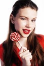 Young pretty brunette girl with red candy posing on white background isolated Royalty Free Stock Photo