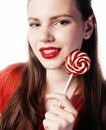 Young pretty brunette girl with red candy posing on white background isolated Royalty Free Stock Photo