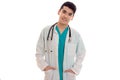 Young pretty brunette male doctor in uniform with stethoscope on his neck posing on camera isolated on white background Royalty Free Stock Photo