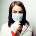 Young pretty brunette woman doctor with stethoscope smiling, wearing gloves and mask on face, lifestyle real people Royalty Free Stock Photo