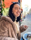 Young pretty brunette woman eating ice cream at the street cafe at Paris, France. Outdoor lifestyle portrait. Royalty Free Stock Photo